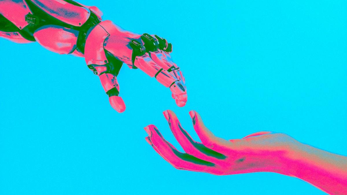 A robot hand and a human hand reaching towards each other
