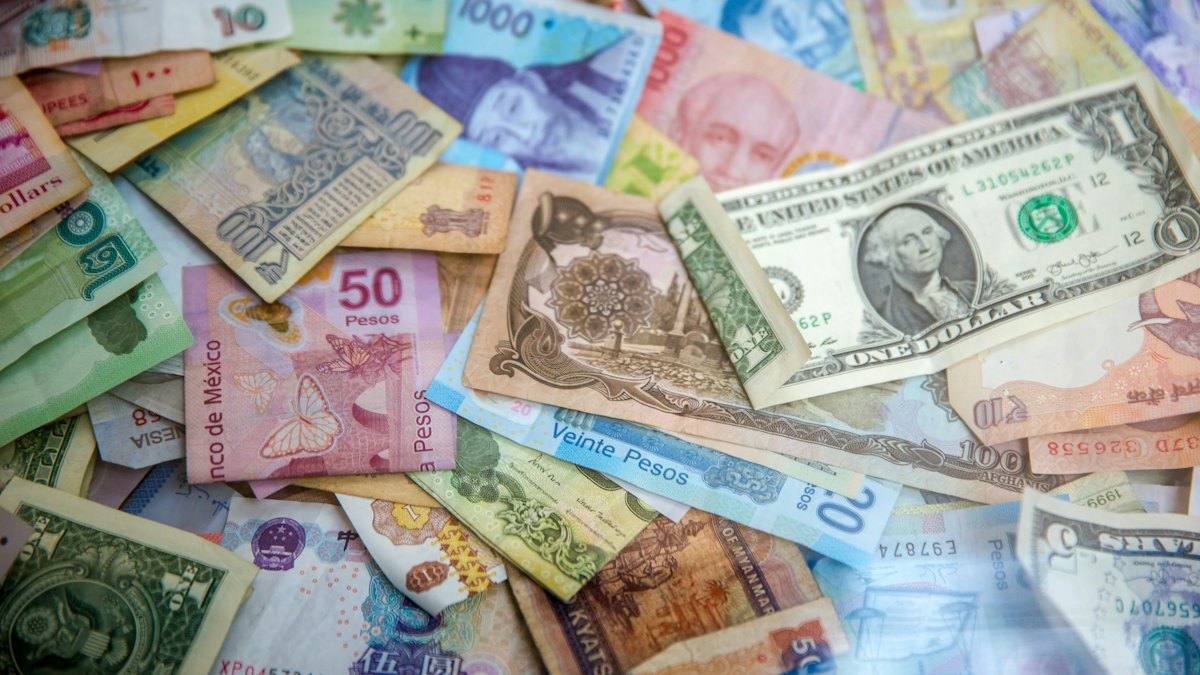Banknotes from many countries spread across a table